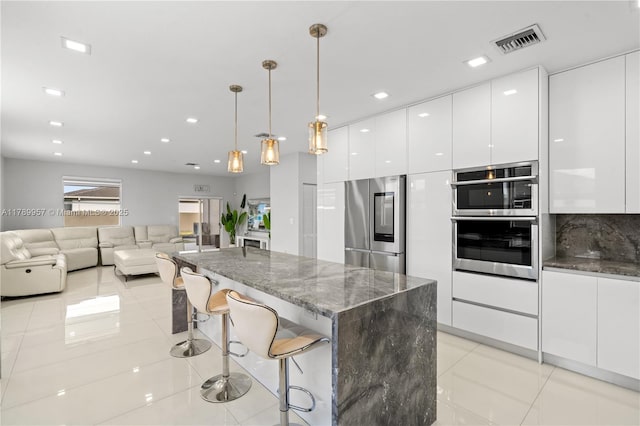 kitchen featuring white cabinets, modern cabinets, visible vents, and appliances with stainless steel finishes
