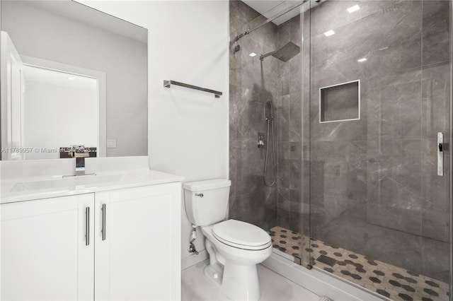 full bathroom with toilet, vanity, and a stall shower