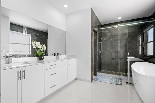 full bath featuring a shower stall, a soaking tub, tile patterned flooring, and a sink