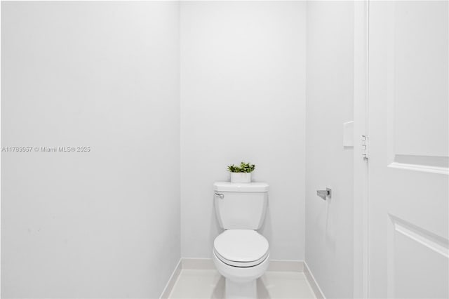 bathroom featuring baseboards and toilet