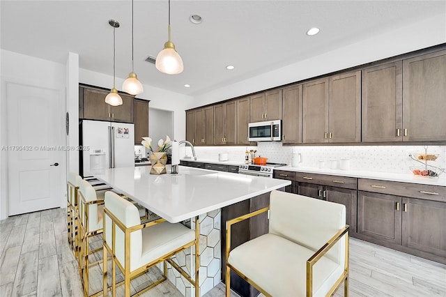 8650 NW 39th Ct, Coral Springs, FL 33065 - kitchen featuring a kitchen island with sink, dark brown cabinets, white refrigerator with ice dispenser, backsplash, and stainless steel electric range oven