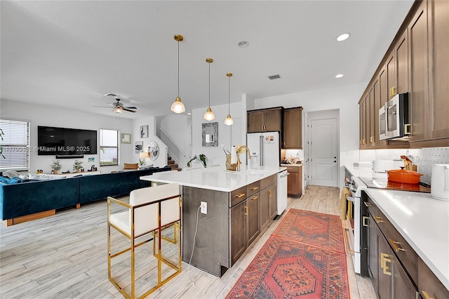 8650 NW 39th Ct, Coral Springs, FL 33065 - kitchen with ceiling fan, visible vents, light countertops, light wood finished floors, and white appliances