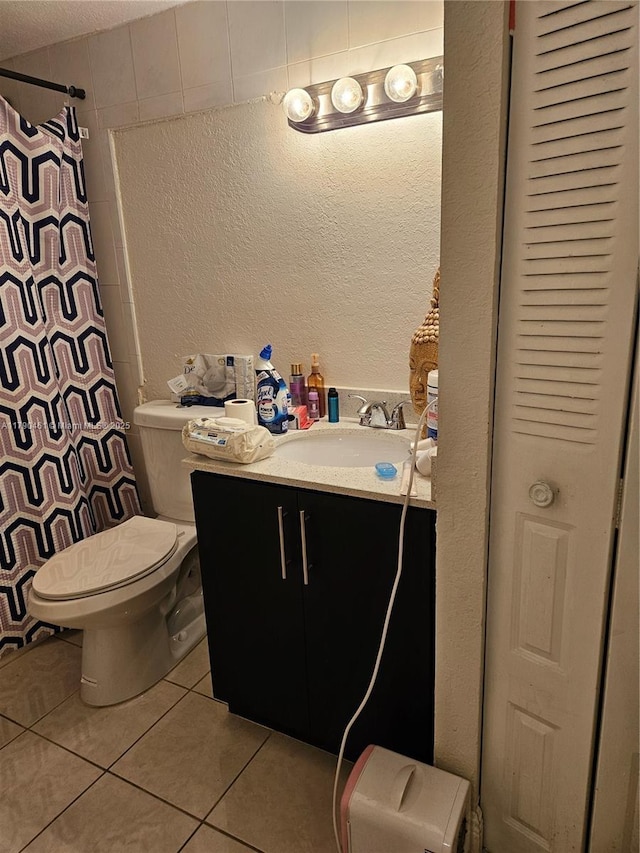 full bathroom featuring tile patterned flooring, a textured wall, toilet, vanity, and a shower with shower curtain