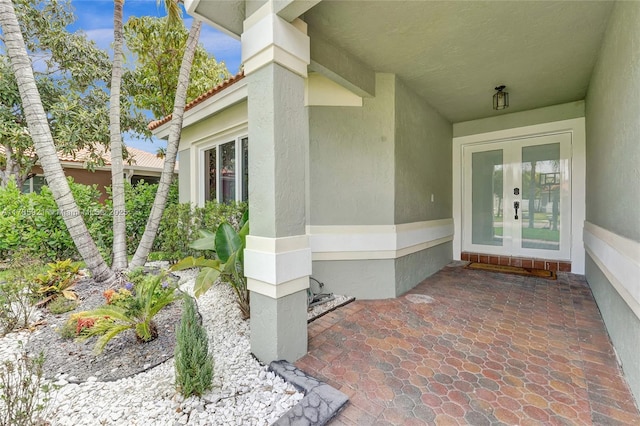 entrance to property featuring french doors and stucco siding