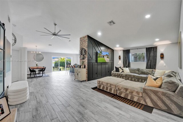 living room featuring light wood-style flooring, vaulted ceiling, visible vents, recessed lighting, and a ceiling fan