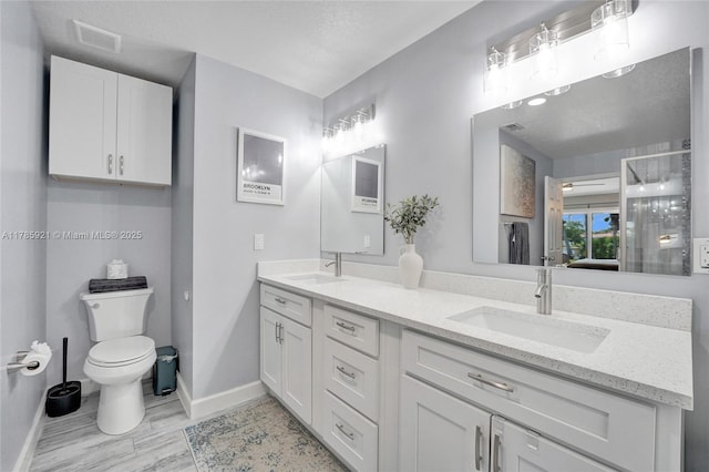 full bathroom with toilet, baseboards, and a sink