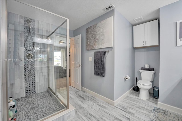 full bathroom with toilet, baseboards, visible vents, wood finished floors, and a shower stall
