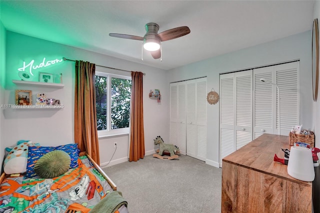 bedroom with two closets, a ceiling fan, baseboards, and carpet
