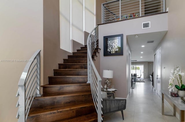 stairs with a high ceiling, visible vents, and recessed lighting
