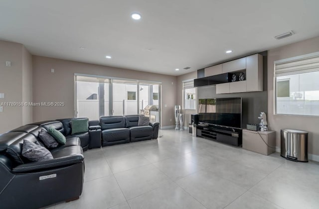 living area featuring light tile patterned floors, baseboards, visible vents, and recessed lighting