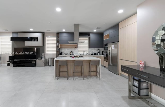 kitchen featuring island range hood, modern cabinets, high end refrigerator, a center island, and a kitchen bar