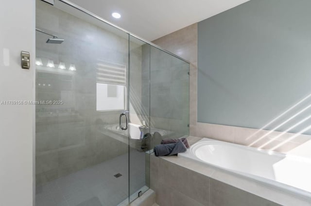 full bathroom featuring a bath and a stall shower