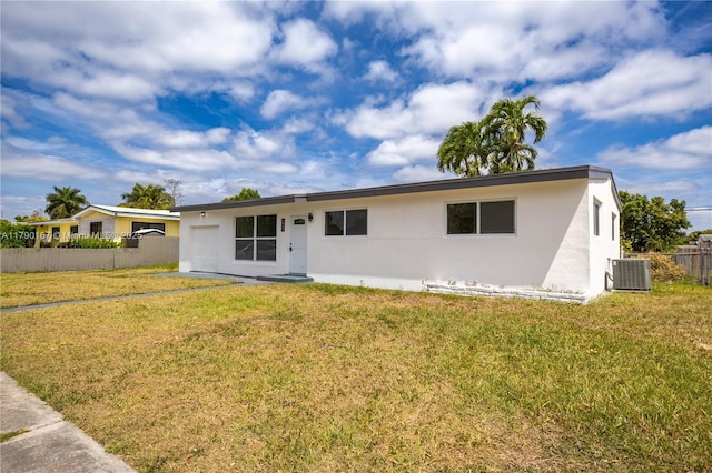 ranch-style home featuring stucco siding, central AC unit, a front yard, and fence