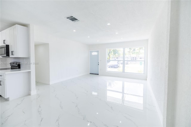 unfurnished living room featuring recessed lighting, visible vents, marble finish floor, and baseboards