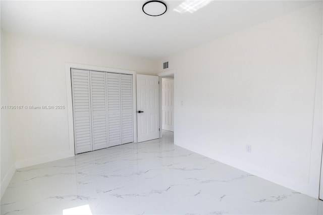 1625 NW 9th Ct, Homestead, FL 33030 - unfurnished bedroom featuring baseboards, light marble finish flooring, and a closet
