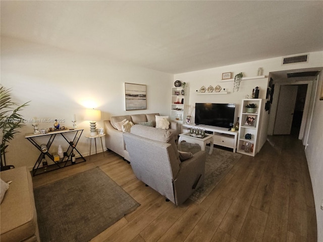 living area with wood finished floors and visible vents