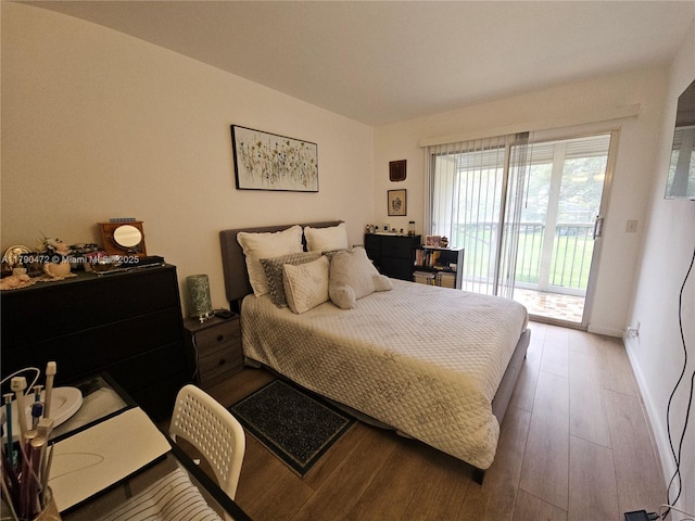 bedroom featuring wood finished floors, access to exterior, and baseboards