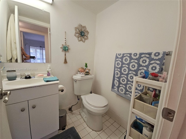 bathroom featuring baseboards, toilet, tile patterned flooring, and vanity