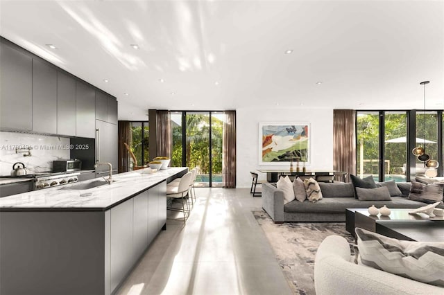 living room featuring recessed lighting, finished concrete flooring, expansive windows, and plenty of natural light