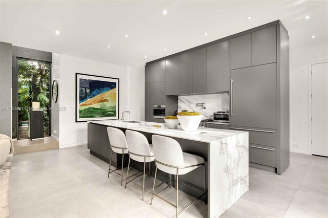 121 2nd Dilido Ter, Share A, Miami Beach, FL 33139 - kitchen featuring gray cabinetry, modern cabinets, a large island with sink, and oven