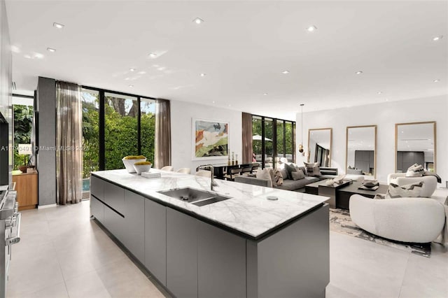 kitchen featuring recessed lighting, a large island, a sink, open floor plan, and modern cabinets
