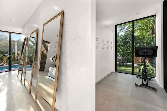 interior space featuring french doors, a healthy amount of sunlight, concrete flooring, and expansive windows