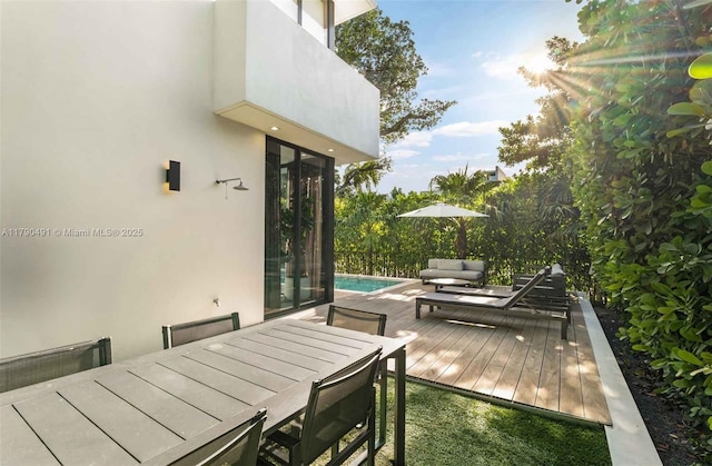 deck with outdoor dining space and an outdoor pool