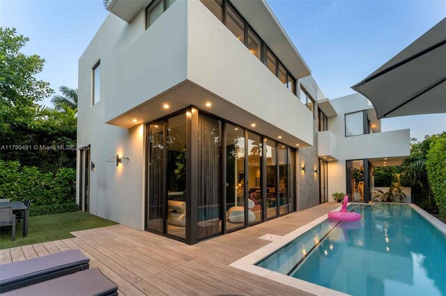 121 2nd Dilido Ter, Share A, Miami Beach, FL 33139 - back of house with stucco siding, an outdoor pool, and a wooden deck