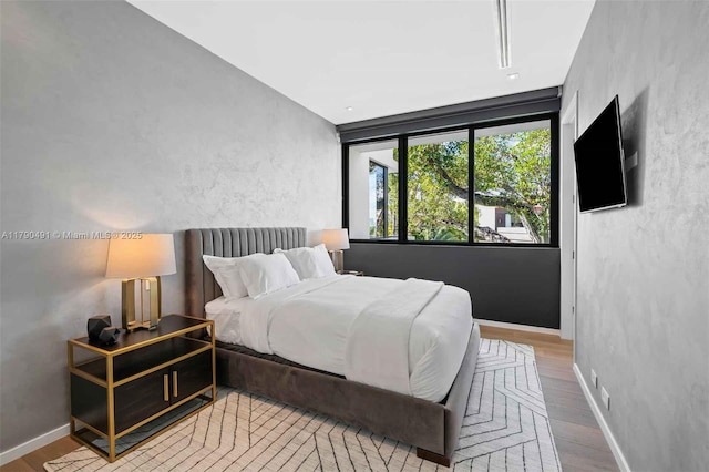 bedroom featuring baseboards and wood finished floors