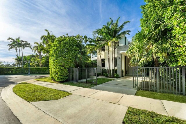 121 2nd Dilido Ter, Share A, Miami Beach, FL 33139 - view of front facade featuring stucco siding, fence, and concrete driveway