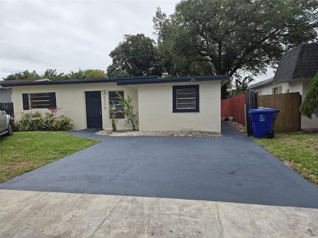 6308 Cleveland St, Hollywood, FL 33024 - ranch-style house featuring fence, a front lawn, aphalt driveway, and stucco siding