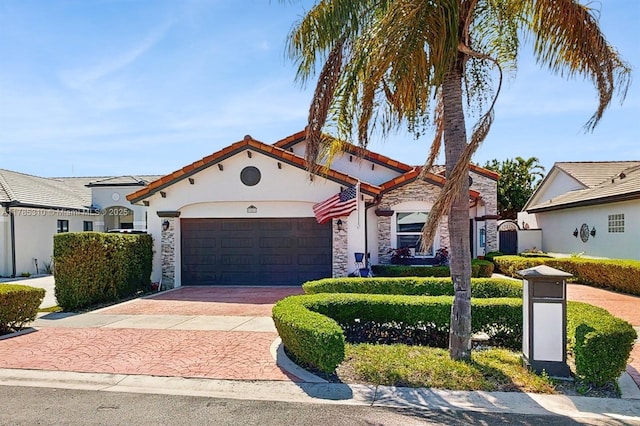 982 NW 133rd Ct, Miami, FL 33182 - mediterranean / spanish-style home with a garage, decorative driveway, stone siding, stucco siding, and a tile roof