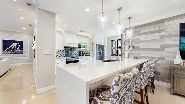982 NW 133rd Ct, Miami, FL 33182 - kitchen featuring appliances with stainless steel finishes, a breakfast bar, white cabinets, light countertops, and crown molding