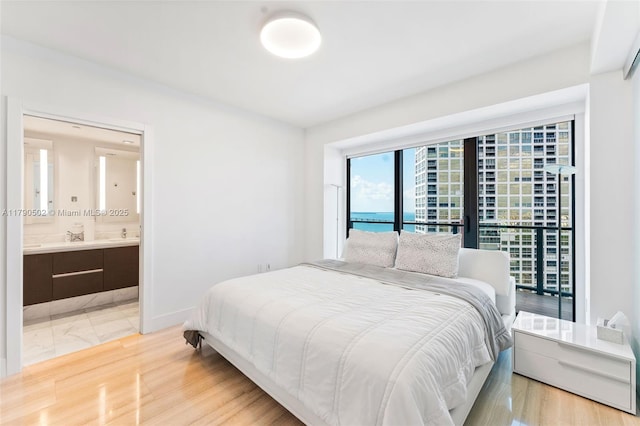 1451 Brickell Ave Unit 1803, Miami, FL 33131 - bedroom featuring baseboards, connected bathroom, and access to exterior