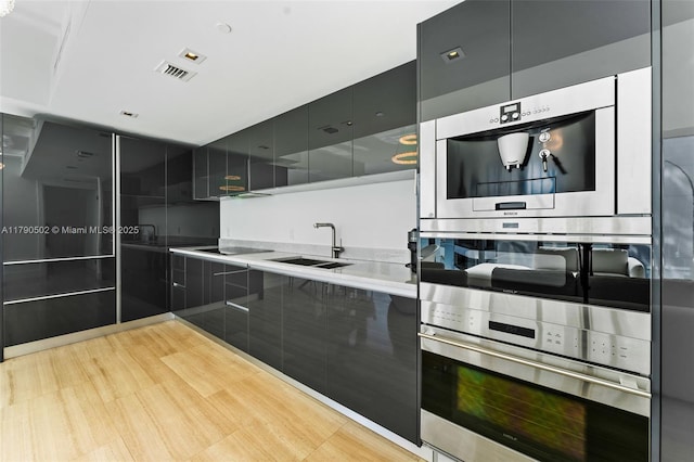 1451 Brickell Ave Unit 1803, Miami, FL 33131 - kitchen featuring black electric cooktop, a sink, modern cabinets, and visible vents