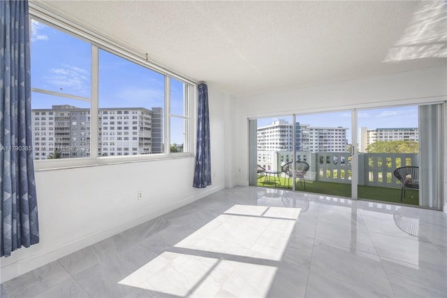 4001 Hillcrest Dr Unit 601, Hollywood, FL 33021 - empty room with a city view, marble look tile flooring, and a textured ceiling