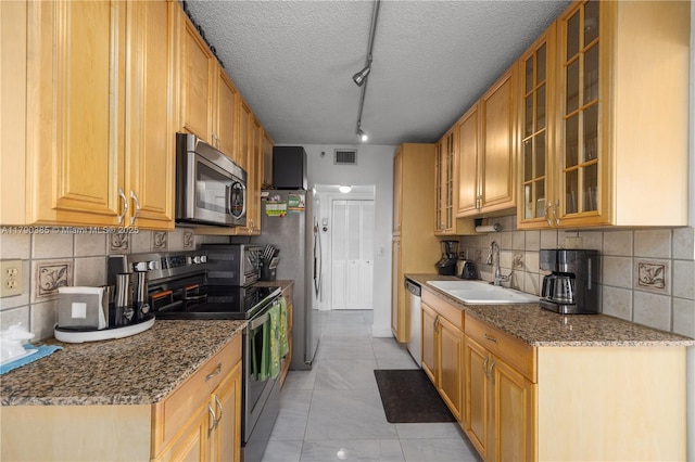 4001 Hillcrest Dr Unit 601, Hollywood, FL 33021 - kitchen with appliances with stainless steel finishes, backsplash, track lighting, stone counters, and glass insert cabinets