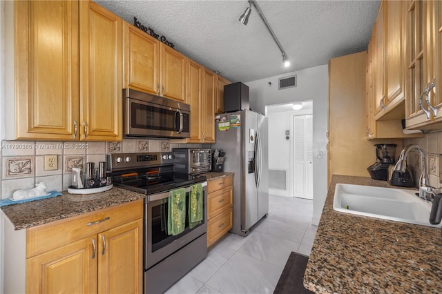 4001 Hillcrest Dr Unit 601, Hollywood, FL 33021 - kitchen with appliances with stainless steel finishes, a textured ceiling, track lighting, light tile patterned floors, and decorative backsplash
