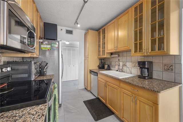 4001 Hillcrest Dr Unit 601, Hollywood, FL 33021 - kitchen with stainless steel appliances, tasteful backsplash, a textured ceiling, light tile patterned floors, and glass insert cabinets