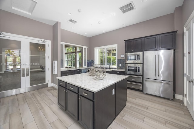 4001 Hillcrest Dr Unit 601, Hollywood, FL 33021 - kitchen with stainless steel appliances, french doors, wood finish floors, a center island, and backsplash