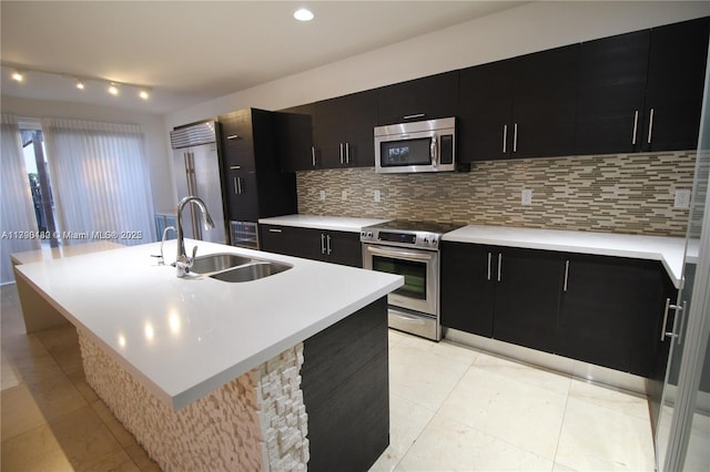 kitchen with dark cabinets, a sink, and appliances with stainless steel finishes
