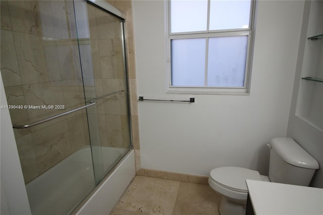 bathroom with toilet, a healthy amount of sunlight, vanity, and combined bath / shower with glass door