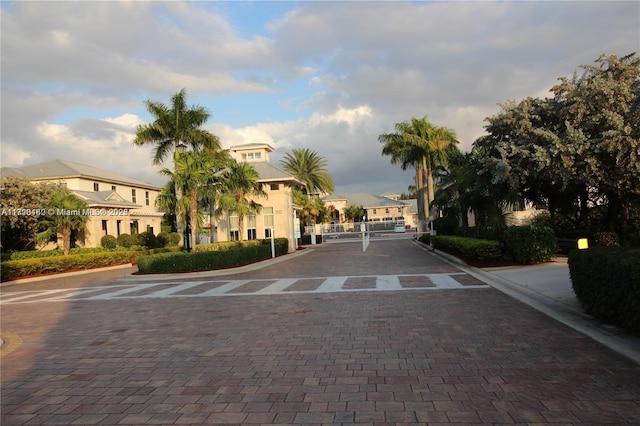 view of street featuring a gate, a gated entry, and curbs