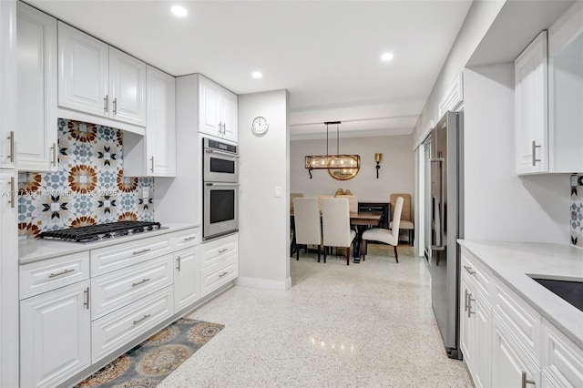 9460 NW 3rd St, Pembroke Pines, FL 33024 - kitchen with stainless steel appliances, backsplash, white cabinetry, a chandelier, and dark aggregate flooring