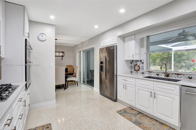 9460 NW 3rd St, Pembroke Pines, FL 33024 - kitchen featuring appliances with stainless steel finishes, a sink, baseboards, dark aggregate flooring, and white cabinets
