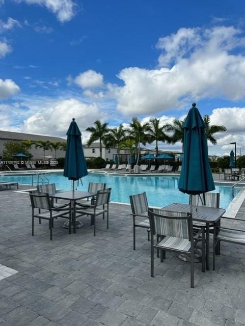 pool featuring outdoor dining area and a patio