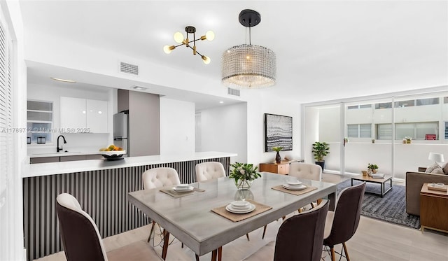 840 NW 87th Ave Unit 204, Miami, FL 33172 - dining space with visible vents, a notable chandelier, and light wood-style flooring