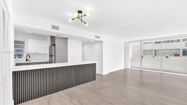 840 NW 87th Ave Unit 204, Miami, FL 33172 - unfurnished living room with an inviting chandelier, visible vents, baseboards, and light wood-style floors