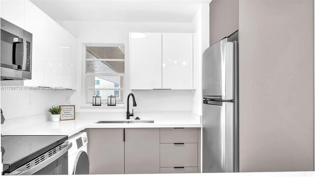 840 NW 87th Ave Unit 204, Miami, FL 33172 - kitchen featuring modern cabinets, washer / dryer, stainless steel appliances, and a sink