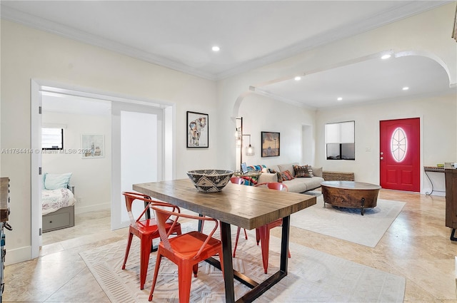 dining room featuring arched walkways, a healthy amount of sunlight, ornamental molding, and recessed lighting